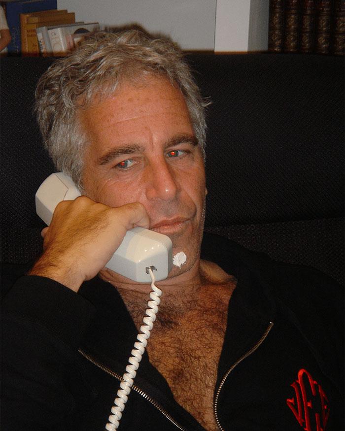 Man talking on a corded phone in an indoor setting, related to Epstein files and Dalai Lama controversy.