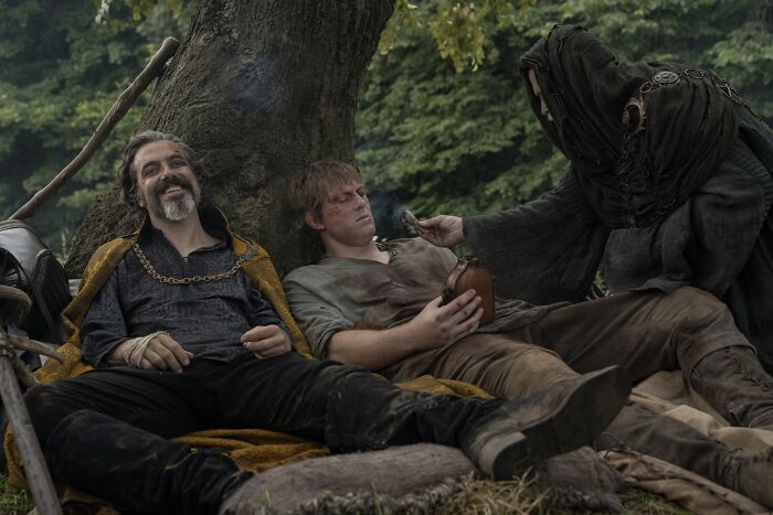 Three characters relaxing under a tree in A Knight Of The Seven Kingdoms, highlighting changes from the Dunk and Egg book.