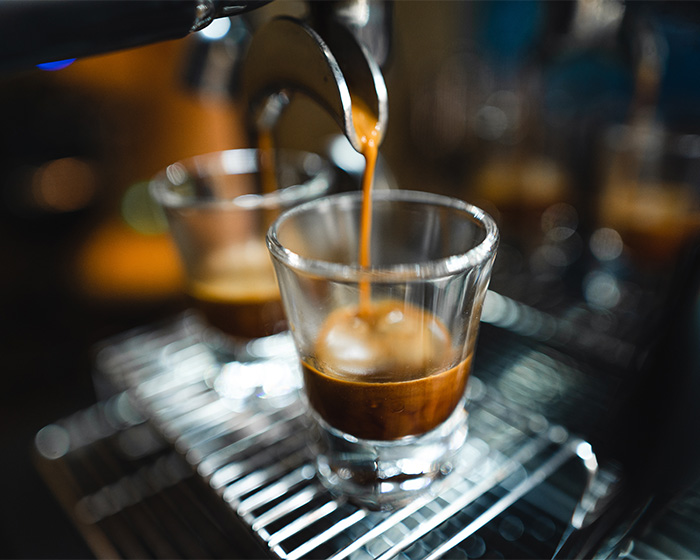 Close-up of coffee being poured into a small glass, illustrating the context of colorectal cancer symptoms awareness.