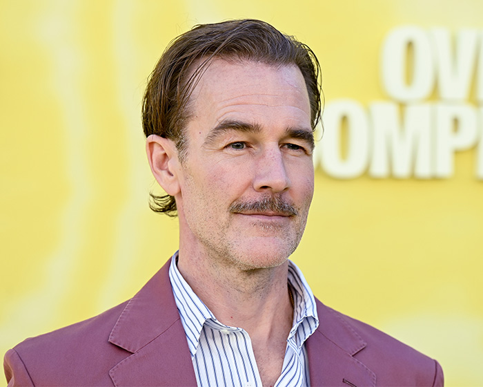 Man with mustache in a striped shirt and maroon jacket against a yellow background discussing colorectal cancer symptoms