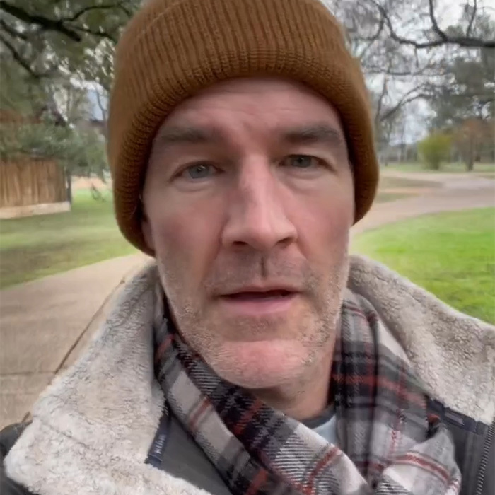 Man wearing brown knit cap and plaid scarf outdoors, discussing commonly ignored colorectal cancer symptoms.