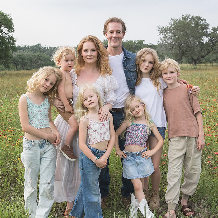 Family posing outdoors in a field, illustrating colorectal cancer symptoms awareness related to a doctor's explanation.