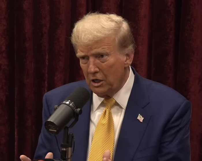 Donald Trump speaking into a microphone during a podcast as UFO files release and Elon Musk&rsquo;s daughter accusation news emerges.
