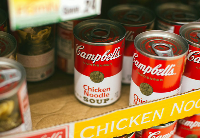 Cans of Campbell's chicken noodle soup on a store shelf, illustrating criminals shockingly bad at what they do.