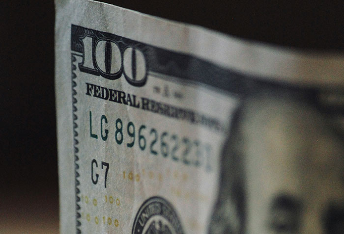 Close-up of a $100 bill, highlighting money linked to criminals shockingly bad at what they do in failed crimes.