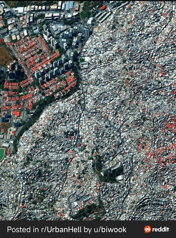 Aerial view of densely packed urban area contrasting orderly buildings and chaotic shantytown in a dystopian nightmare setting.