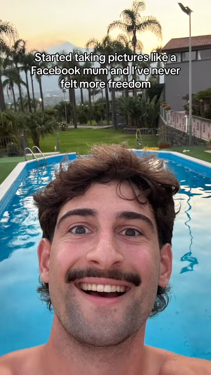 Smiling man taking a chaotic mom selfie by a pool with palm trees, capturing the energetic vibe of social media moms.