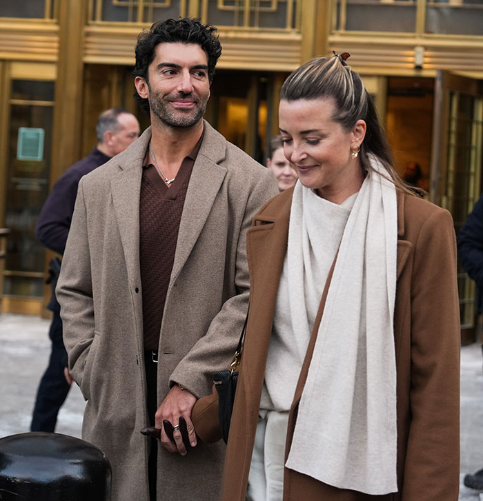 Couple dressed in brown coats outside courthouse, highlighting world class privilege in a public setting.