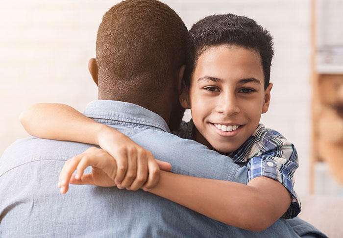 Aunt hugging nephew warmly at home, showing care and support in a close family moment. Aunt hugging nephew warmly at home, showing care and support in a close family moment.