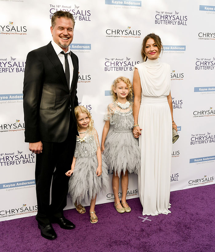 Eric Dane and family posing on purple carpet at Chrysalis Butterfly Ball event, dressed in elegant formal attire.