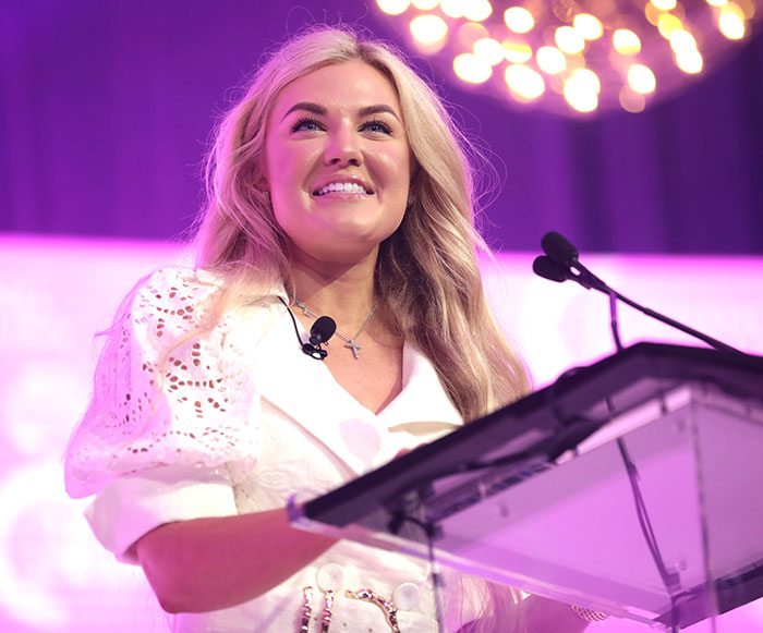 Erika Kirk speaking at podium under bright lights, main SEO keywords about her relationship and office changes.