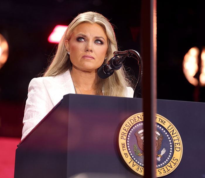 Erika Kirk speaking at a podium with the presidential seal, relationship and office changes under fan scrutiny.