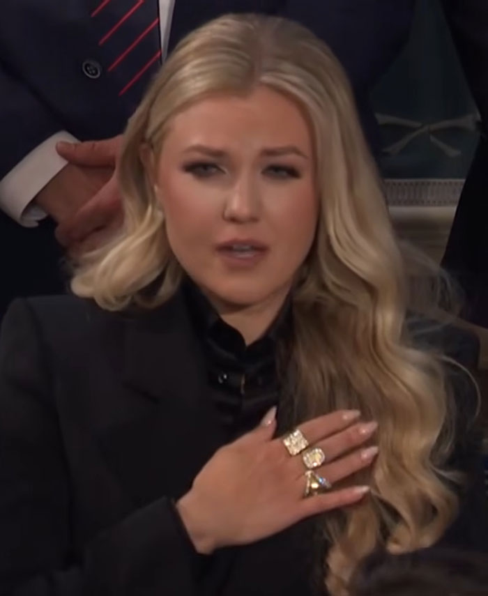 Erika Kirk at State of the Union, wearing black attire with long blonde hair and multiple rings on her hand.