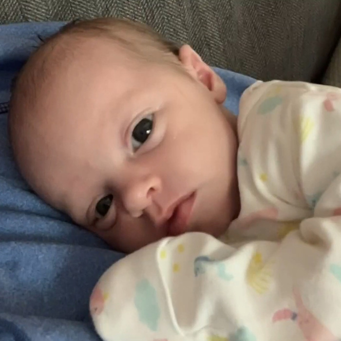 Close-up of a young baby girl lying down, highlighting the tragic passing and horrifying exchange between young parents.