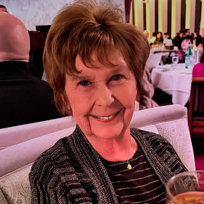 Smiling elderly woman seated in a restaurant, related to expert insights on Nancy Guthrie kidnapper&rsquo;s pivotal moment.