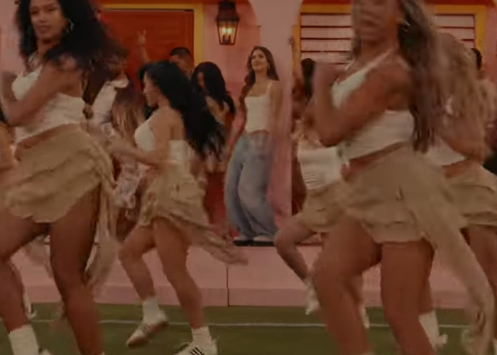 Jessica Alba dancing with backup dancers during a Super Bowl halftime show performance on a football field.