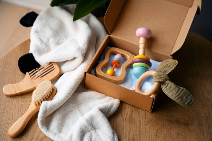 Baby fever concept with wooden toys and soft towel in a box, hinting at pregnancy preparations and family excitement.