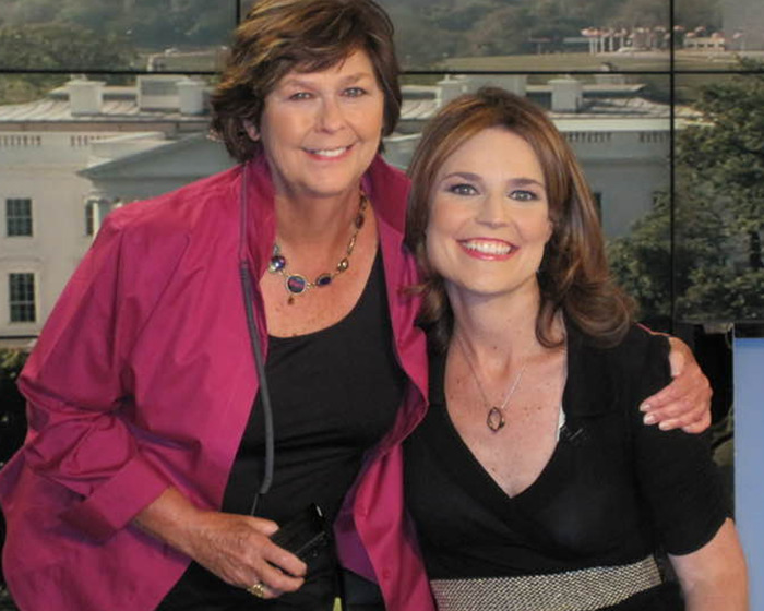 Two women smiling together in front of a window with an outdoor view, related to FBI ransom note details.