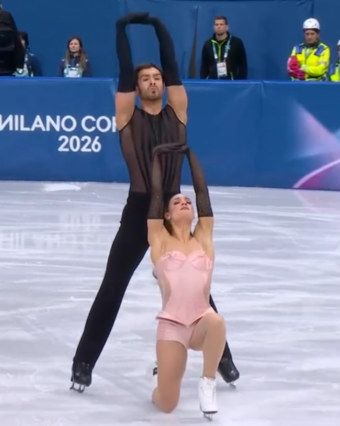 Figure skating pair performing a routine on ice as fans discuss suspicious scoring and judge controversies.