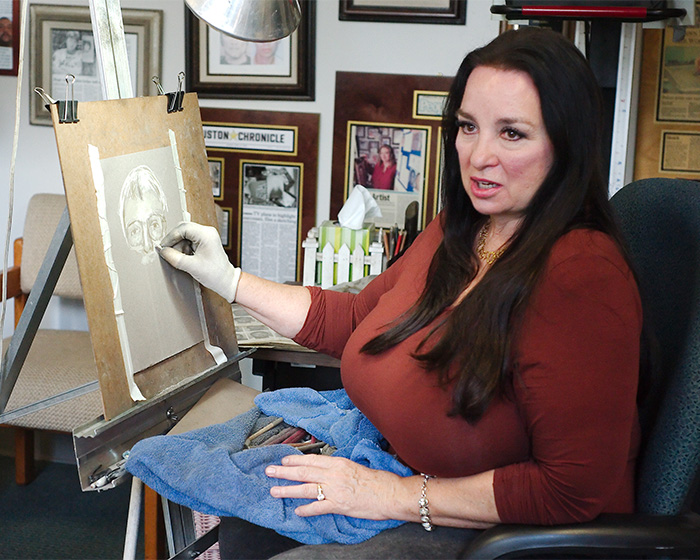 Forensic artist creating first sketch of Nancy Guthrie's masked suspect inside an office filled with framed photos.