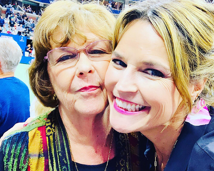Two women smiling closely together at a crowded event, with forensic white tent setup mentioned in the background context.