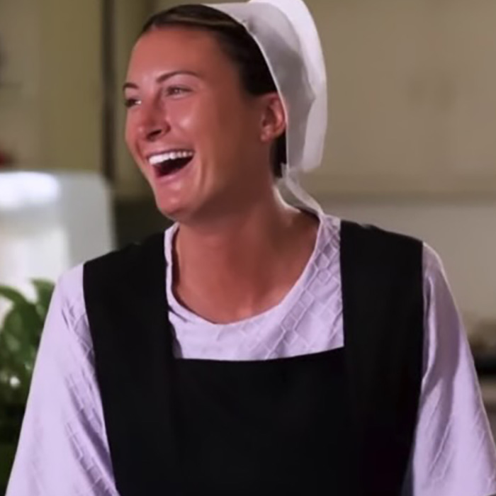 Young woman dressed in Amish clothing smiling happily, representing former adult star joining Amish community in Pennsylvania.