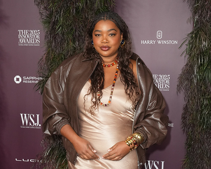 Woman at The 2025 Innovator Awards wearing a leather jacket and gold dress, representing ex-Vogue editor and micro-aggression claims.