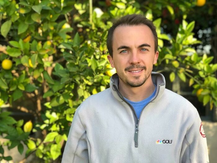 Young man in a light gray golf jacket standing outdoors with greenery, representing iconic actors who dominated Hollywood then vanished.