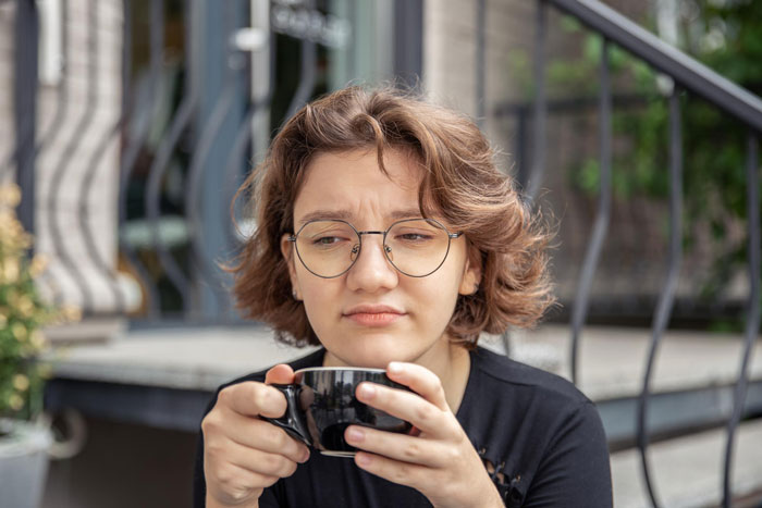 Woman holding a cup with a worried expression after her $500 Yixing teapot was ruined by a house-sitting friend Woman holding a cup with a worried expression after her $500 Yixing teapot was ruined by a house-sitting friend