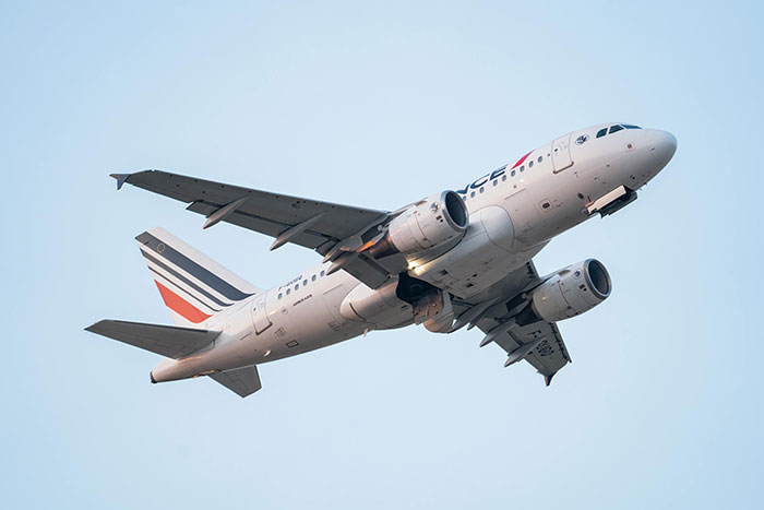 Commercial airplane in flight against a clear sky, symbolizing unexpected moments under anesthesia keywords.