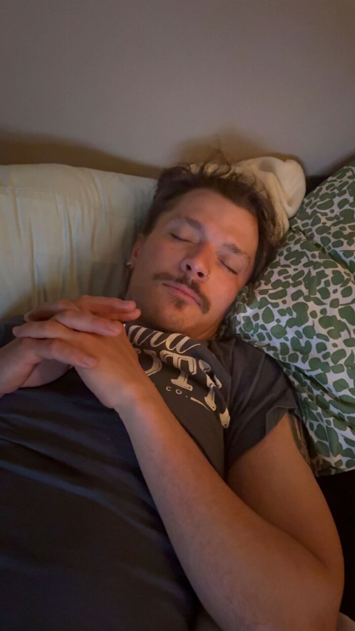 Man lying down with hands awkwardly clasped, eyes closed, showing awkward body language that can give women the ick.