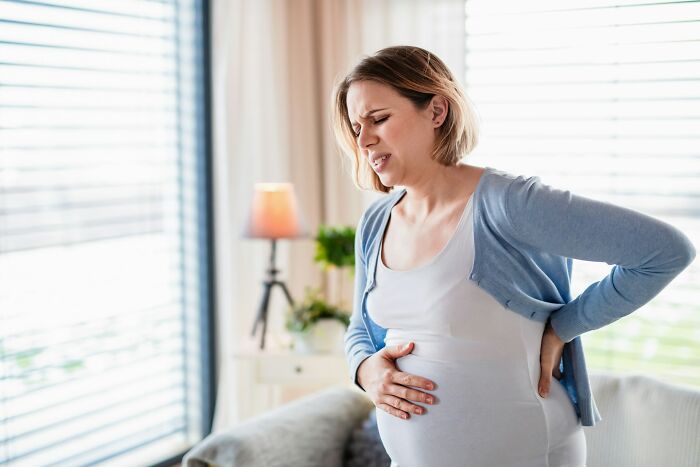 Pregnant woman experiencing discomfort at home, symbolizing strange things that made people question everything.