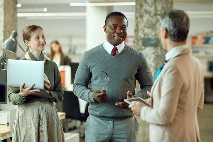 Three employees engaging in a tense discussion illustrating toxic workplace moments in an office setting.
