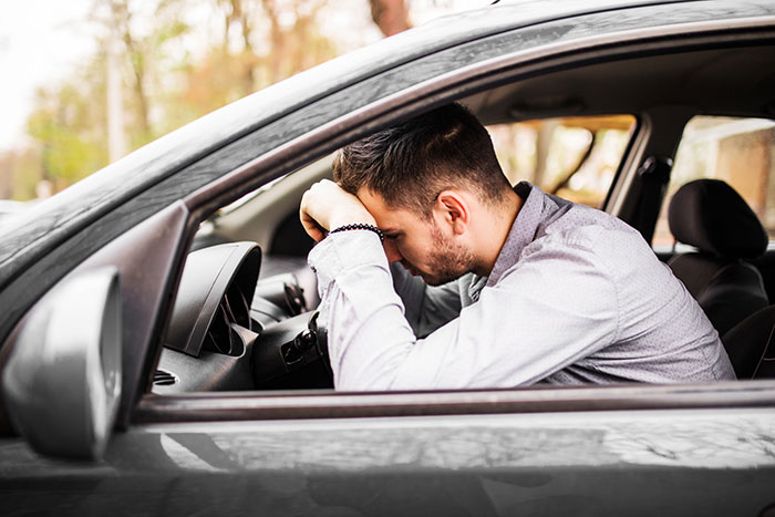 Young man in car looking stressed and suspicious, possibly dealing with girlfriend’s second phone use and trust issues. Young man in car looking stressed and suspicious, possibly dealing with girlfriend’s second phone use and trust issues.