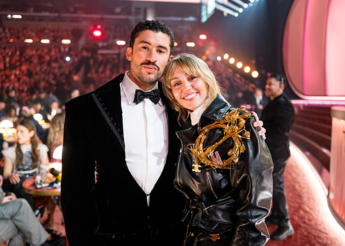 Grammy seatfiller posing with a woman at the event, highlighting harsh rules faced during the Grammy Awards ceremony.