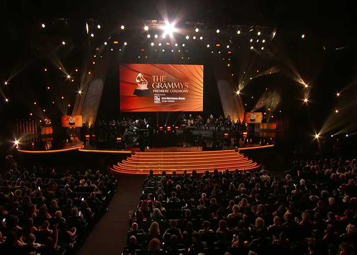 Grammy Awards stage with audience and band, highlighting fashion trends from 2016 Grammys in a grand ceremony setting