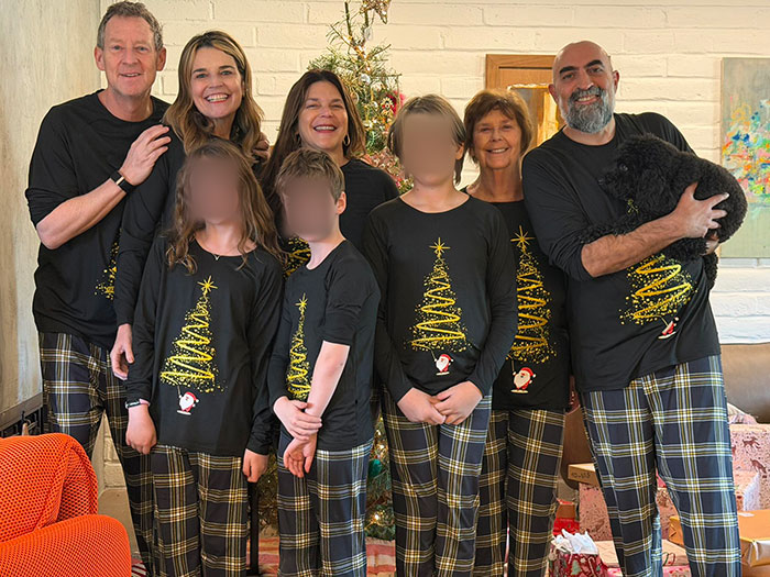 Family wearing matching holiday pajamas in a living room during Christmas, related to Savannah Guthrie's mom search update.