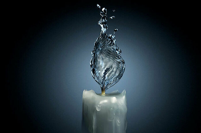 A candle with a flame made of water captured mid-splash, showcasing unhinged and wild pics without Photoshop.