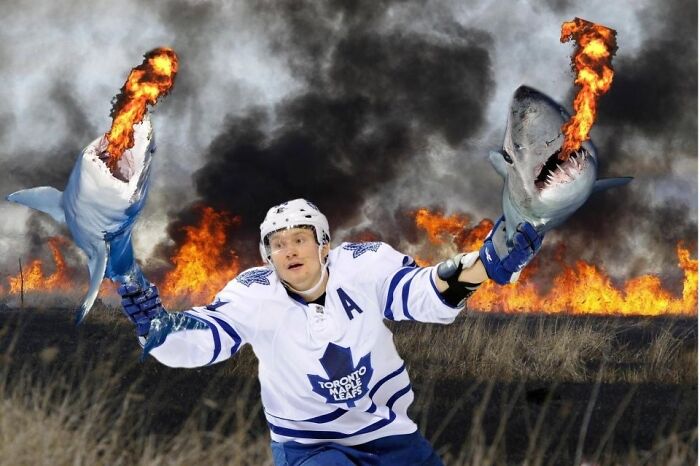 Hockey player holding flaming sharks with fire and smoke in the background in unhinged wild pics without Photoshop.