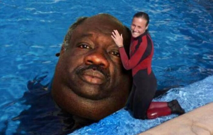 Woman in wetsuit hugging an unhinged and wild photoshopped giant head floating in pool water.