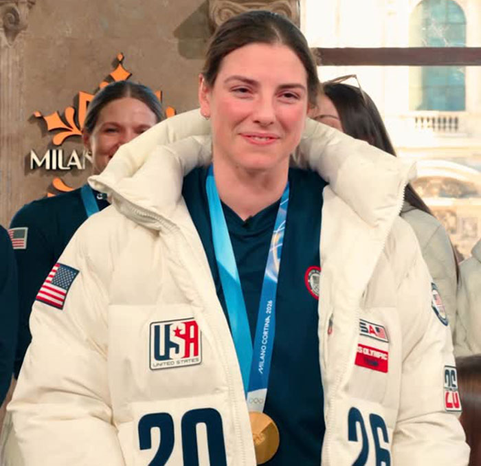 US women's hockey player wearing gold medal and team jacket after breaking silence on Trump's remark
