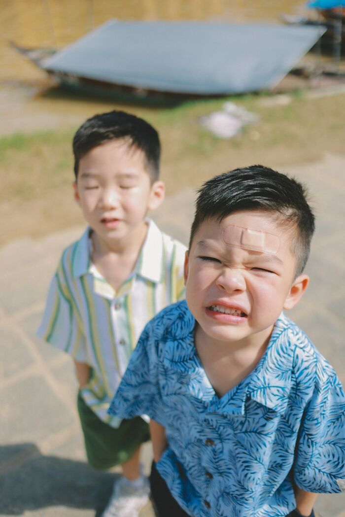 Two young boys outside, one with a bandage on his forehead, illustrating problematic childhood beliefs about girls and eating.