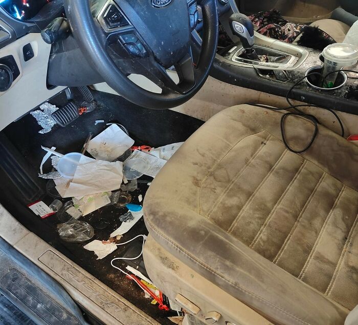 Messy car interior with trash and stains on the seat, reflecting wild dating experiences that made people question reality.