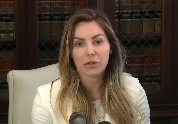 Woman speaking at a press conference, discussing a bombshell claim about Playboy founder Hugh Hefner.