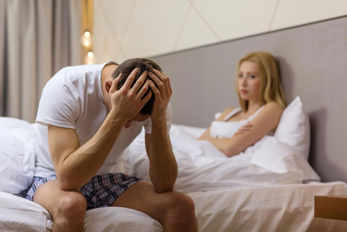 Wife realizes lack of comfort from husband, both showing emotional distance and frustration in a bedroom setting. Wife realizes lack of comfort from husband, both showing emotional distance and frustration in a bedroom setting.