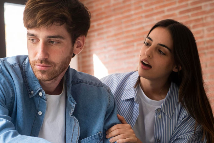 A woman trying to talk to a distant man, depicting tension and emotions in a husband best friend cheating scenario.