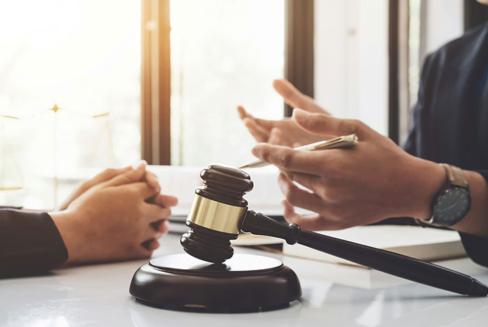 Couple discussing issues with husband leaving and coming back, with a judge's gavel in focus on the table.