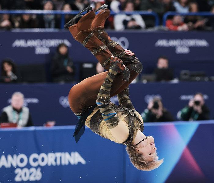Figure skater performing a mid-air flip during the 2026 Winter Olympics, showcasing one of the wildest bizarre moments.