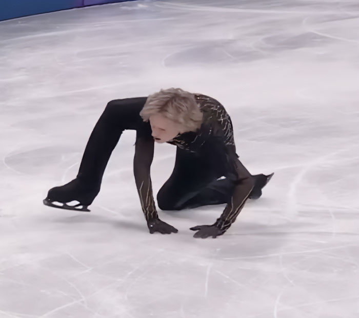 Figure skater Ilia Malinin in a black costume on ice after a major defeat, sparking concern from fans over troubling posts.