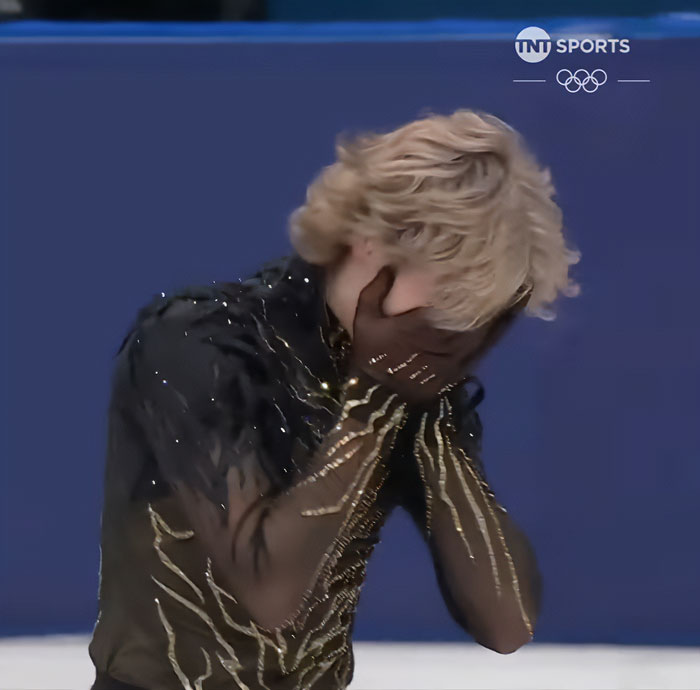 Olympic star Ilia Malinin covers his face during a performance, raising concern after fans spot troubling posts on his profile.